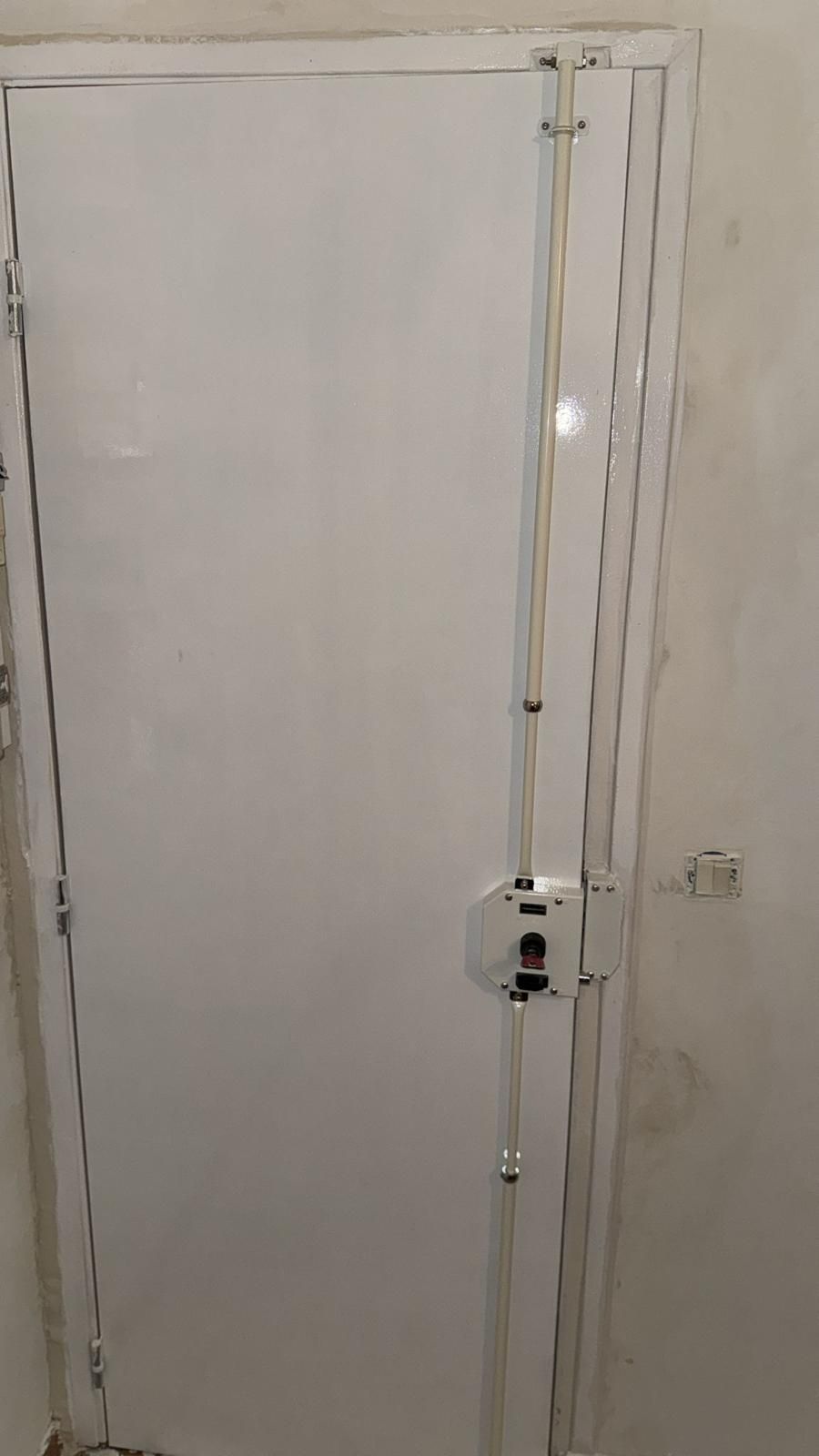Serrure multipoints à tringles sur une porte d'entrée blanche