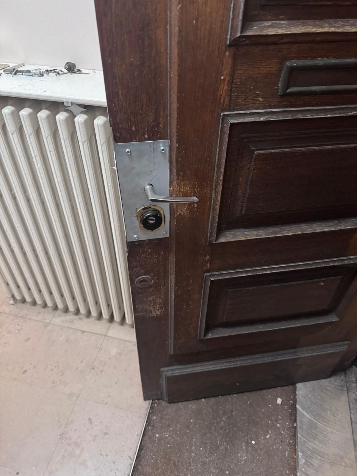 Serrure neuve avec poignée posée sur une porte en bois massif