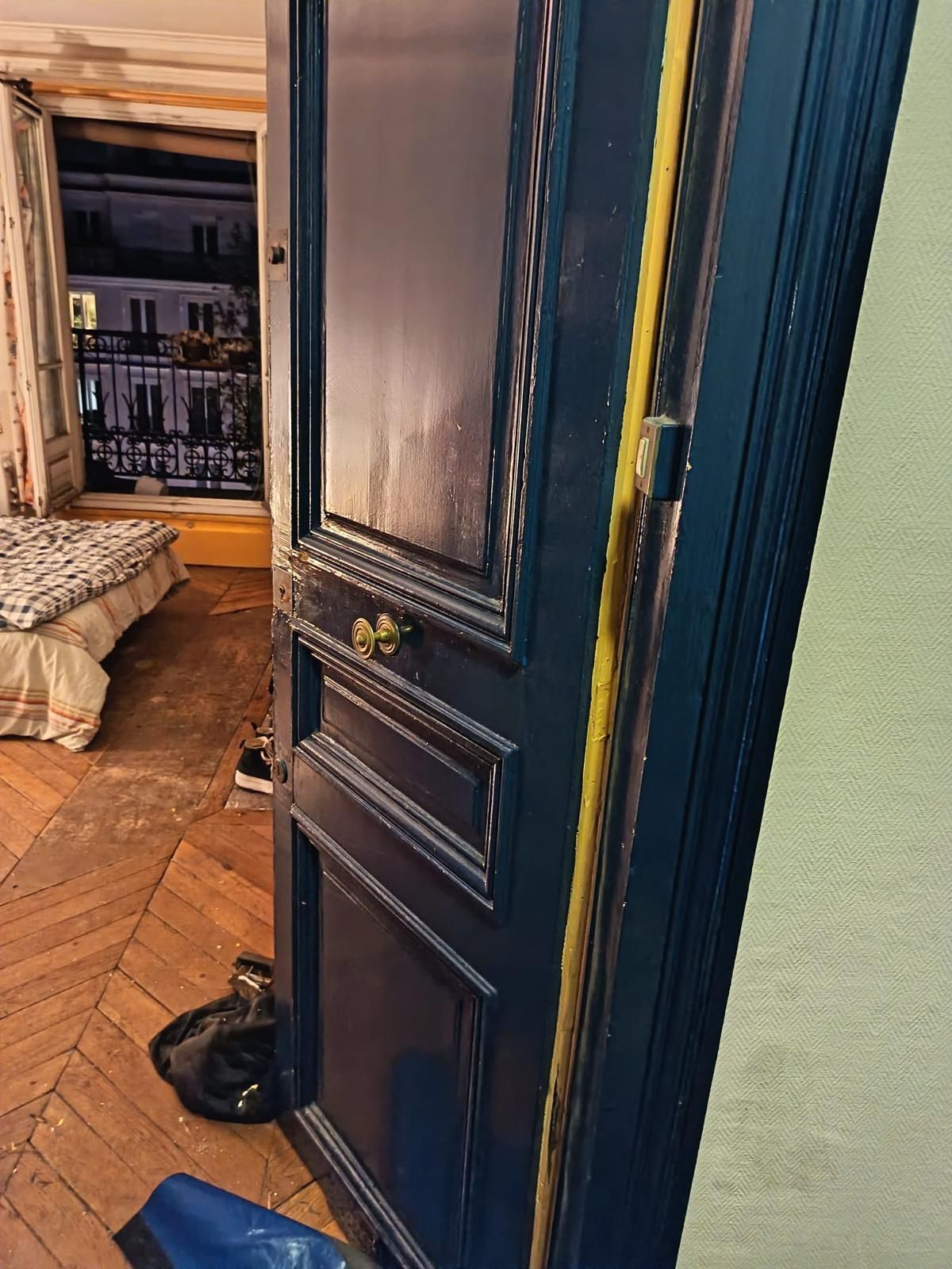 Porte d'appartement à moulures ouverte, gâche neuve posée sur le bâti