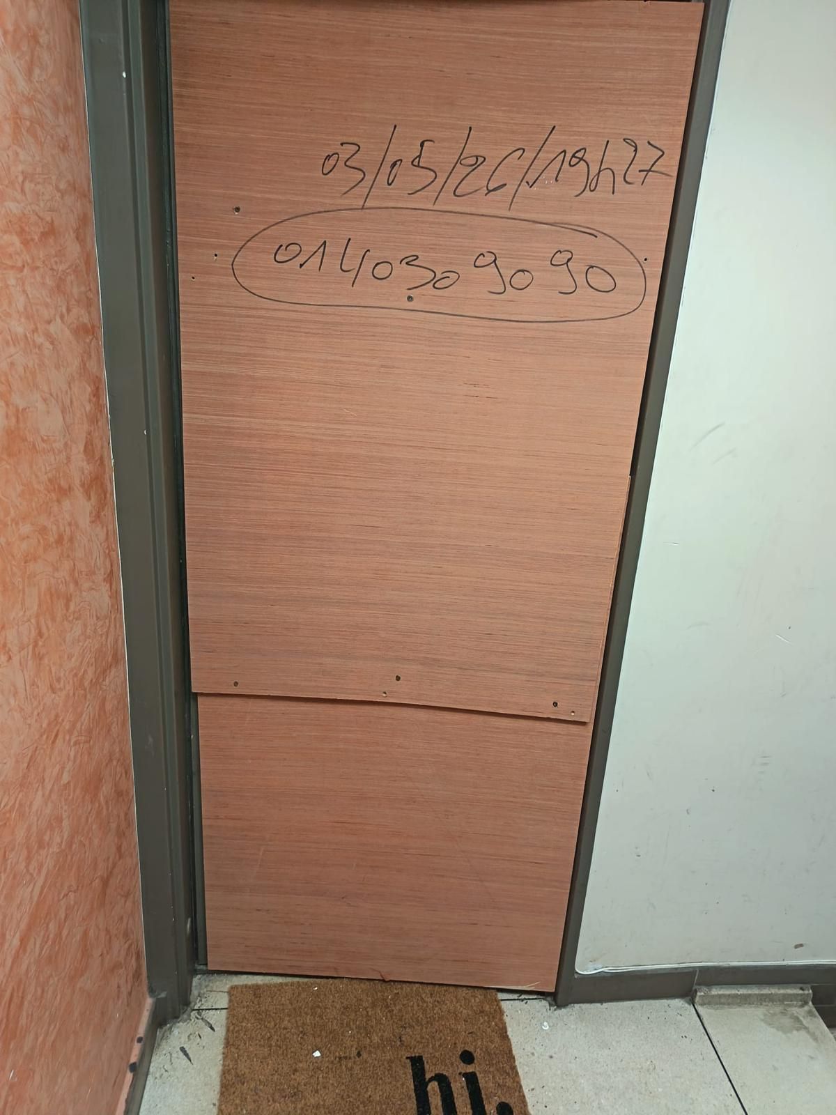 Porte palière fermée provisoirement par un panneau de contreplaqué